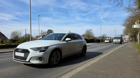 We can see a reasonable amount of traffic on Norwich Road, with a silver Audi in the foreground.