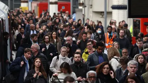 Crowds of people getting off a train at Waterloo station