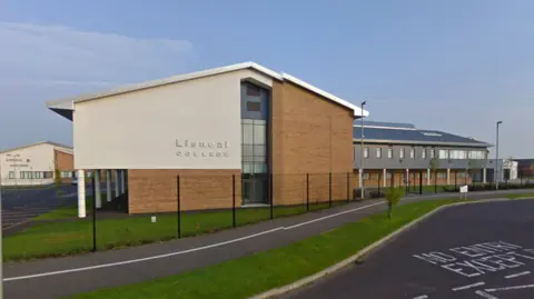 Google Maps A screengrab of Lisneal College from Google Maps.  The large brown brick and grey render building has a slanted roof. It is surrounded by grass and a black security fence.