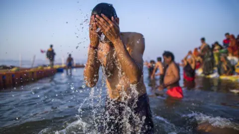 A pilgrim bathes at the ritual bathing site known as the Sangam, which is located at the confluence of three holy rivers the Ganges, the Yamuna and the mythical Saraswati during the Kumbh Mela in Prayagraj, Uttar Pradesh, India, on Wednesday, Jan. 16, 2019. India's Prime Minister Narendra Modi's Hindu nationalist party catering to Hindus is on full show at the Kumbh Mela, the worlds biggest religious gathering. The Bharatiya Janata Party is betting that religious nationalismincluding allocating almost $600 million to a mass Hindu pilgrimagecan shore up its vote in elections due by May. Photographer: Prashanth Vishwanathan/Bloomberg via Getty Images