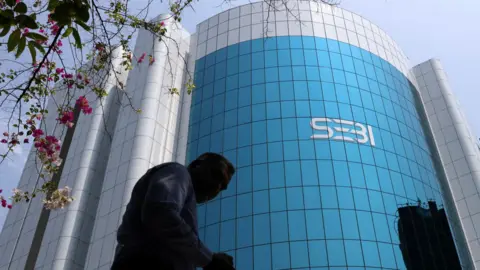 A man walks past the Securities and Exchange Board of India (SEBI) headquarters in Mumbai, India, April 19, 2023.