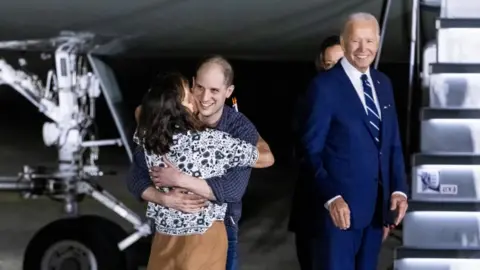 EPA President Joe Biden watches as Wall Street Journal reporter Evan Gershkovich greets his mother after being freed from Russian detention.